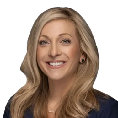 Woman with long blonde hair wearing a navy blazer over a burgundy top, smiling, photographed against a white background.