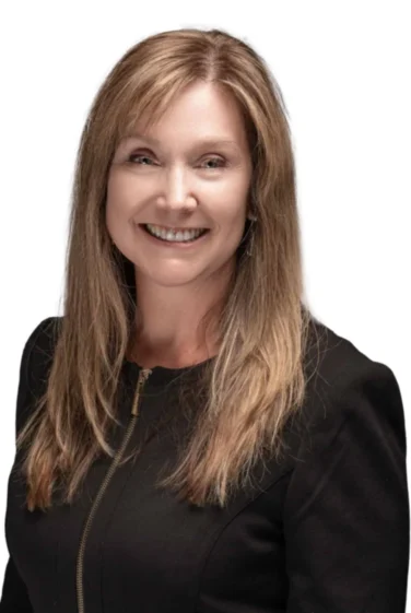 Woman with straight, light brown hair wearing a black zippered top, smiling, and facing slightly to the side against a white background.