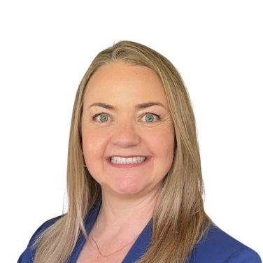 A middle-aged woman with blonde hair smiling, wearing a blue blazer over a light-colored top.