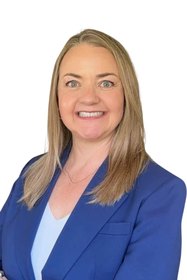 A middle-aged woman with blonde hair smiling, wearing a blue blazer over a light-colored top.