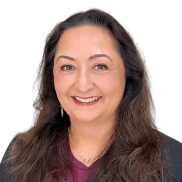 A smiling woman with long dark hair wearing a maroon top and a black blazer.